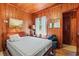 Cozy bedroom featuring wood paneling, a comfy bed, and natural light from the window at 506 28Th Ave. N, Myrtle Beach, SC 29577