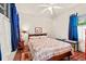 Bright bedroom with a ceiling fan, wood-paneled walls, a bed with a quilt, and blue curtains at 506 28Th Ave. N, Myrtle Beach, SC 29577