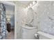 Updated bathroom with white marble tiles, decorative wallpaper and updated lighting at 520 13Th Ave. N, Surfside Beach, SC 29575