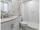 Updated bathroom with white marble tiles, decorative wallpaper, and glass-enclosed shower at 520 13Th Ave. N, Surfside Beach, SC 29575