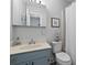 Bathroom features a blue vanity, a mirror, toilet and shower with white curtain at 520 13Th Ave. N, Surfside Beach, SC 29575