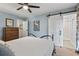 Light-blue bedroom with ceiling fan, barn-door to marble bathroom, and wooden dresser at 520 13Th Ave. N, Surfside Beach, SC 29575