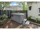 A grey hot tub is surrounded by greenery and a wooden fence in the backyard at 520 13Th Ave. N, Surfside Beach, SC 29575