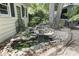 Beautiful backyard pond with a waterfall feature, lush plants, and gravel walkway at 520 13Th Ave. N, Surfside Beach, SC 29575