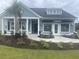 Attractive blue home with a well-manicured lawn, complete with a palm tree and a Lennar sales office at 526 Magnolia Terrace Dr, Myrtle Beach, SC 29579