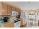Kitchen with white appliances, wooden cabinets, tile floor, and bay window at 556 Crusade Circle, Conway, SC 29526