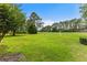 Expansive backyard view of the golf course showcasing meticulously maintained greenery and mature trees at 583 Wildflower Trail, Myrtle Beach, SC 29579