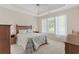 Comfortable bedroom featuring a tray ceiling, soft carpet, and natural light from a window at 583 Wildflower Trail, Myrtle Beach, SC 29579