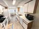Kitchen featuring white appliances and cabinetry, wood-look flooring, and an eat-in area at 6001-B5 S Kings Hwy., Myrtle Beach, SC 29575