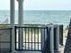 Beach view from the deck, with a black metal fence and a white staircase post at 6001-B5 S Kings Hwy., Myrtle Beach, SC 29575