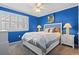 Bright bedroom with blue walls, white trim, ceiling fan and large window at 611 2Nd Ave. S # 18-C, North Myrtle Beach, SC 29582