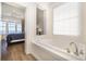 Bathroom with a soaking tub, adjacent to the bedroom with natural light and coastal views at 611 N Ocean Blvd., Surfside Beach, SC 29575