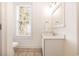 Bright bathroom featuring a single vanity with a white countertop and a window view of a palm tree at 611 N Ocean Blvd., Surfside Beach, SC 29575