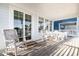 Inviting porch with rocking chairs and a dining set, perfect for enjoying outdoor meals and relaxation at 611 N Ocean Blvd., Surfside Beach, SC 29575
