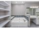 Bathroom featuring a soaking tub with decorative tile, vanity and built-in shelves at 612 Intracoastal Way Dr. # 103, Myrtle Beach, SC 29579