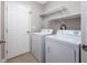 Functional laundry room with tile floors, washer, dryer, and built in shelving for optimal organization at 612 Intracoastal Way Dr. # 103, Myrtle Beach, SC 29579