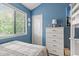 Comfortable bedroom with blue walls, a window, a bed, and a white dresser with a lamp at 614 14Th Ave. S # 47, Surfside Beach, SC 29575