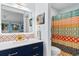 Stylish bathroom featuring a modern vanity with vibrant patterned tiles and colorful shower curtain at 620 15Th Ave. S # 87, Surfside Beach, SC 29575