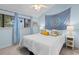 Bright bedroom featuring a mandala tapestry, soft blue walls, and plush white bedding at 620 15Th Ave. S # 87, Surfside Beach, SC 29575