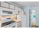 Well-lit kitchen with white appliances, cabinets, solid countertops, and neutral backsplash at 620 15Th Ave. S # 87, Surfside Beach, SC 29575