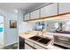 Kitchen with white cabinets, double sink, and a view into the living room, promoting an open layout at 620 15Th Ave. S # 87, Surfside Beach, SC 29575