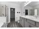 Well-lit bathroom featuring double sinks, sleek cabinets, glass shower, and wood-look tile flooring at 628 Mccorkle Place, Conway, SC 29526