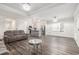 Open-concept living room with hardwood floors and a view of the modern kitchen with stainless steel appliances at 628 Mccorkle Place, Conway, SC 29526