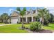 Charming brick home featuring a well-manicured lawn and palm trees at 698 Lafayette Park Dr., Little River, SC 29566