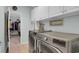 Functional laundry room with washer, dryer, white cabinets, and access to walk-in closet at 698 Lafayette Park Dr., Little River, SC 29566