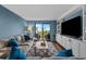 Bright living room features a sofa and entertainment center; sliding glass doors open to balcony views at 7601 N Ocean Blvd. # 7-C, Myrtle Beach, SC 29572
