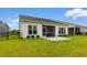 View of the backyard featuring a well-manicured lawn, a screened-in patio, and white exterior at 908 Pelagic Loop, Myrtle Beach, SC 29579
