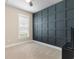 Serene bedroom with dark blue accent wall, window, carpet flooring, and modern trimwork at 908 Pelagic Loop, Myrtle Beach, SC 29579