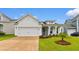 Charming white home featuring a manicured lawn, two-car garage and covered porch, perfect for relaxed living at 908 Pelagic Loop, Myrtle Beach, SC 29579