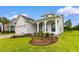 Beautiful white home with meticulously landscaped front yard and inviting covered porch and a view of the garage at 908 Pelagic Loop, Myrtle Beach, SC 29579