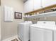 Functional laundry room featuring white appliances, shelving, and ample storage space at 908 Pelagic Loop, Myrtle Beach, SC 29579