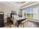 Serene main bedroom with a tray ceiling, bench, large window, and hardwood floors at 908 Pelagic Loop, Myrtle Beach, SC 29579