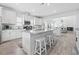 Open kitchen with white cabinets, granite counters, an island with stools and wood-look floors at 914 Mary Read Dr., North Myrtle Beach, SC 29582