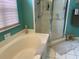 Bathroom with a tub and shower, tile floors, neutral colored towels, and teal colored walls at 9614 Indigo Creek Blvd., Murrells Inlet, SC 29576