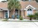 Inviting front exterior with a quaint seating area surrounded by lush landscaping at 9614 Indigo Creek Blvd., Murrells Inlet, SC 29576