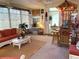 The sunroom features wicker furniture, tropical themed decorations, a ceiling fan, and lots of natural light at 9614 Indigo Creek Blvd., Murrells Inlet, SC 29576