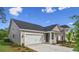 Charming home exterior showcasing neutral siding, a two-car garage, and well-kept landscaping under a blue sky at 9728 Indigo Creek Blvd., Murrells Inlet, SC 29576