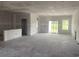 Unfinished spacious living room featuring white walls, sliding doors, and ample natural light at 982 Oak Hollow St., Longs, SC 29568
