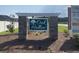 View of the Oak Hollow entrance sign with stone columns and lush landscaping at 985 Oak Hollow St., Longs, SC 29568