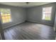 Bright bedroom with neutral walls, laminate floors, and two windows offering natural light at 9888 Conifer Ln., Murrells Inlet, SC 29576
