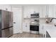 Modern kitchen with stainless steel appliances, white cabinets, and light countertops at 1008 Plantation Dr., Surfside Beach, SC 29575