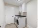 Well-lit laundry room featuring washer, dryer, and crisp white cabinetry at 1008 Plantation Dr., Surfside Beach, SC 29575