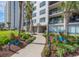 A well-kept building exterior is enhanced by lush landscaping including colorful potted plants and decorative walkway lights at 10200 Beach Club Dr. # 16F, Myrtle Beach, SC 29572