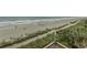 View from the balcony looking down at the beach with trees and a building roof at 1207 S Ocean Blvd. # 20403, Myrtle Beach, SC 29577