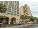 View of condo building featuring multiple stories and balconies, with palm trees in front at 1207 S Ocean Blvd. # 20403, Myrtle Beach, SC 29577