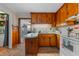 Well-lit kitchen featuring classic wood cabinetry, white appliances, and a breakfast bar at 1217 S Highway 501, Marion, SC 29571